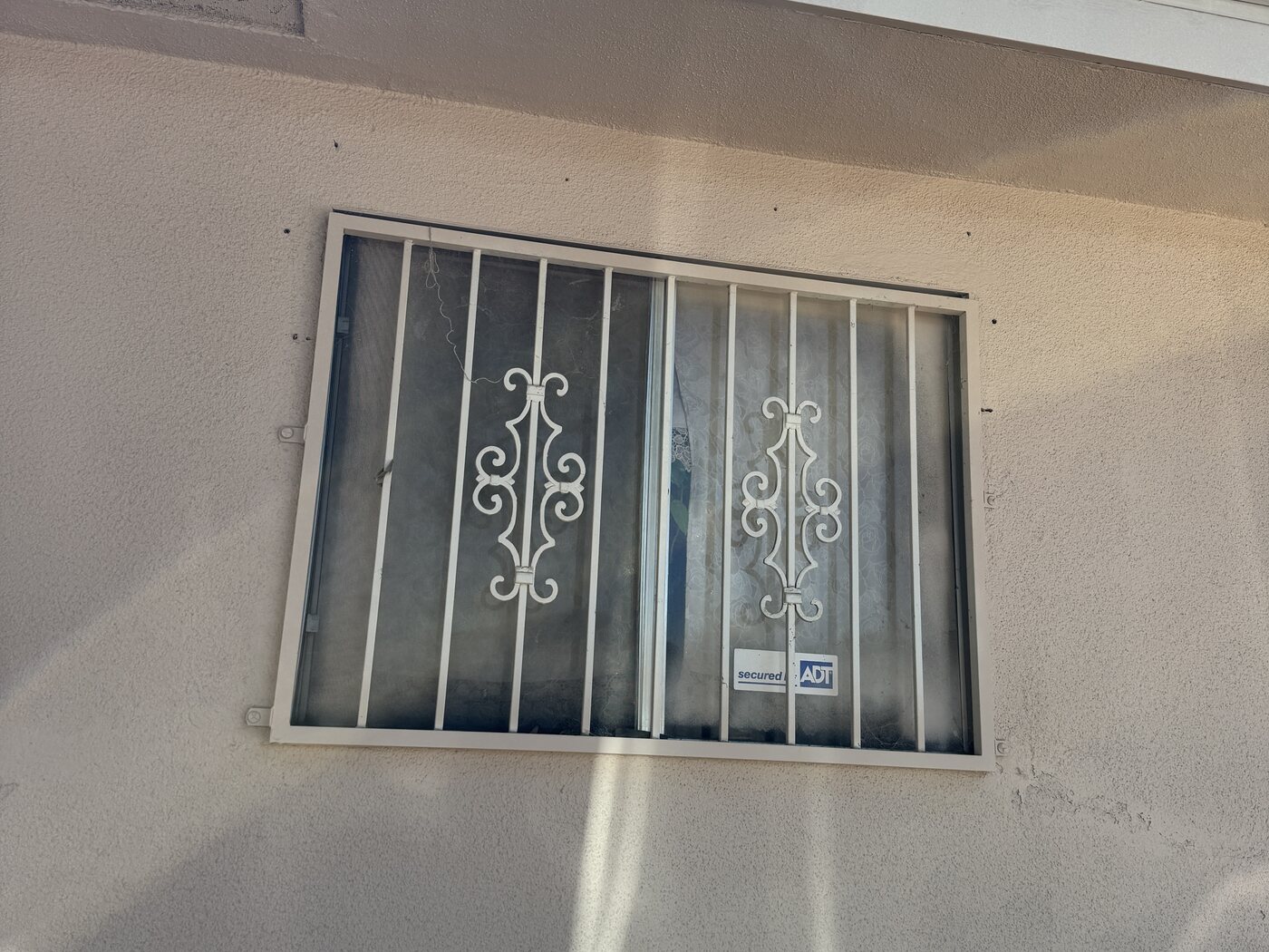 Old louvered window with security bars before replacement in Fresno, CA