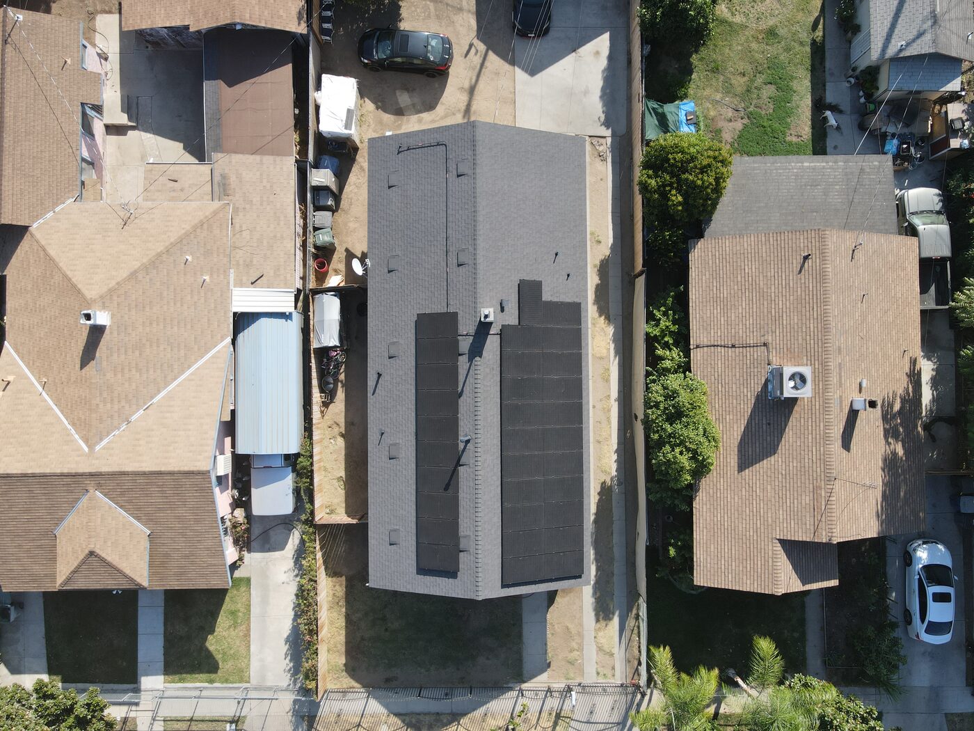 After: the finished charcoal shingle roof with the solar array remounted, seen from above